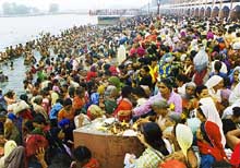 Pilgrims take a dip in Brahma Sarovar as the sun struggles to cast off the veil of clouds soon after the solar eclipse at Kurukshetra on Saturday morning. 