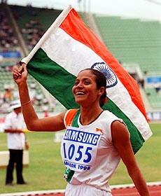 Jyotirmoy Sikdar of India waves India's national flag as she runs a victory lap after winning the Asian Games women's 1,500 meter run in Bangkok on Monday. 