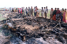 Residents of Nangla Beholpur village look at remains of their belongings.