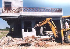 A house nearing completion built in violation of the periphery Act being demolished