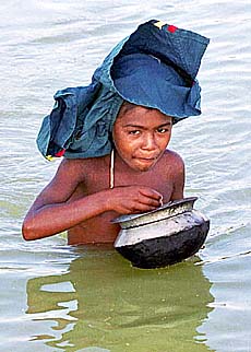 DHAKA : Tofail Ahmed has food while wading through waist-deep water following floods in Dhaka, Bangladesh, on Wednesday. — AP/PTI
