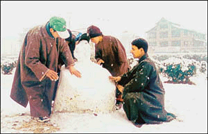 Youngsters make a snowman after a heavy snowfall.
