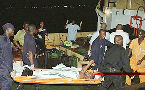A survivor of the Kenya Airways flight 431 calls out a prayer as he is brought ashore from a rescue boat.