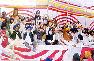 Suspended SAD member Ravi Inder Singh and former SGPC President Gurcharan Singh Tohra raise their hands to pass the resolution read by Mr Prem Singh Chandumajra at the “Punjab bachao, Parkash Singh bhajao” rally held at Badal village in Muktsar district on Saturday.