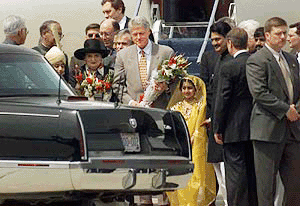 US President Bill Clinton stands with a Pakistani girl in traditional colourful dress after receiving a bouquet at the Pakistan Air Force Chaklala base in Rawalpindi on Saturday.