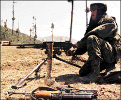 A soldier mans a machine gun at the site of a battle between the security forces and militants at Panchaldhal village in Kashmir on Saturday