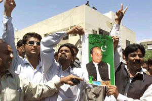 Supporters of Nawaz Sharif, deposed Prime Minister of Pakistan, chant anti-government slogans, holding Sharif's poster, outside the Anti-Terrorist Court in Karachi after the court decision on Thursday