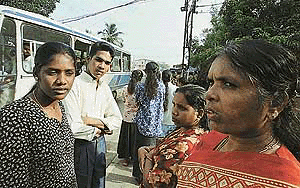 Shsikala Selvarajah (L), a Tamil woman, waits with others at a police station near Colombo on Thursday,