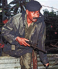 A Fijian soldier climbs over a fence while patrolling near the Parliamentary complex