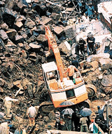 Rescue workers clear debris at the site of a landslide