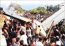 People surround the wreckage of the Alliance Air plane.