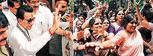 Mr Bal Thackeray waves to his supporters and (right) women dance in jubilation outside a Bombay court after the judge dismissed the case against the Shiv Sena chief on Tuesday