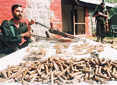 A Special Operations Group man of the Jammu and Kashmir police displays arms and ammunition