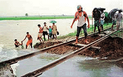 Villagers try to cross a damaged rail track over flood waters in the West Bengal town of Shantipur, 150 km northeast of Calcutta, on Wednesday. 