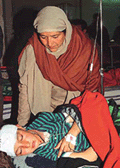 A relative looks after injured Abid (12) in a hospital in Srinagar on Saturday. Four schoolchildren were wounded by a landmine explosion, suspected to have been planted by militants. 