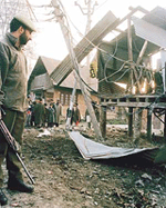 A policeman looks at a damaged electric transformer after an explosion.