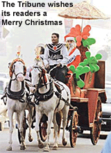 A man dressed as Santa Claus travels on a horse carriage through a busy street in New Delhi on Sunday.