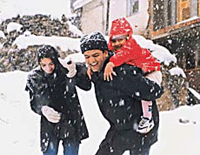 A couple enjoys the first snowfall at Kufri on Monday.