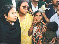 Anisa Bibi (right) shows the charred remains of her two-storeyed house to Railway Minister Mamata Banerjee (left).