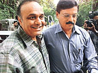 Film financier and diamond merchant Bharat Shah (left) is accompanied by a policeman as he is brought to court in Mumbai on Thursday. 