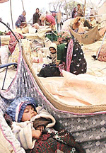 A baby sleeps in a hammock at a makeshift camp built by earthquake survivors at Sukhpar, about 10 km from Bhuj, on Tuesday.