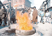 Kashmiri youth burn a tyre in protest against the killing of civilians by the security forces on Sunday.