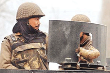 A paramilitary trooper keeps guard atop his armoured vehicle in Srinagar on Thursday. 