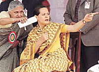 Delhi Chief Minister Sheila Dikshit draws Sonia Gandhis attention to a section of a crowd during a farmers rally in Delhi on Sunday.
