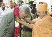 A priest garlands former U.S. President Bill Clinton during his visit to the Akshardham temple in Ahmedabad on Friday.