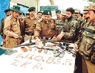 BSF officers display arms and ammunition recovered from a militant hideout, smashed in Ganderbal area on the outskirts of Srinagar on Friday.