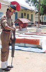 A BSF soldier reverses arms during a wreath-laying ceremony at Praharinagar village of Tura in Assam on Saturday.