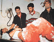 A Kashmiri lies on a stretcher with his trousers drenched in blood.