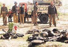 Policemen stand near a pile of uniforms and gear of their dead colleagues after an explosion in Sanoorkalipora village in Beerwah.