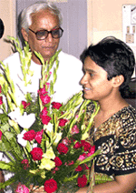 Sucharita Bhattacharjee gives her father, Buddhadeb Bhattacharjee, flowers after his election victory.