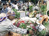 A Nepalese man burns a candle at a temporary altar built for King Birendra and Queen Aishwarya on a street in Kathmandu on Tuesday. 