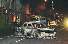 A burnt-out car in Leeds city centre, northern England, after hundreds of Asian rioters piled on to the streets, setting alight cars and throwing bricks on Tuesday.