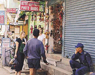 Tourists talking to the owner of a trinkets shop as a policeman looks on after a relaxation in the curfew in Kathmandu on Wednesday.