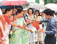 A Nepalese palace servant provides water to members of the public queuing up to sign condolence books and give flowers outside the Royal palace in Kathmandu on Saturday.
