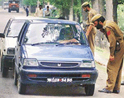 Policemen check the passengers of a car to see whether it is carrying journalists, at Sangam village, 40 km south of Srinagar, on Tuesday. 