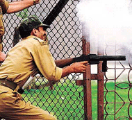 A policeman fires tear-gas canisters at protesters outside Srinagars main mosque on Friday during a one-day strike. 