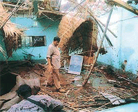 A police officer examines the damaged ruling Awami League Party office in Narayanganj district, 16 km from Dhaka, on Sunday.