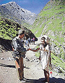 A sadhu shakes hands with a securityman on the trek to the holy cave shrine of Amarnath, where the annual pilgrimage begins on July 4. 