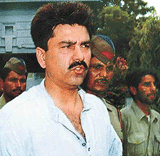 Former Indian Test cricketer Manoj Prabhakar is escorted by the police outside his residence after he was arrested in New Delhi on Monday.