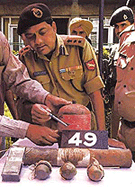 A senior BSF officer inspects an IED fitted in an LPG cylinder, recovered by the troops in Rainawari locality of Srinagar on Tuesday.