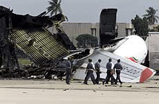 Airmen inspect the remains of a Sri Lankan Airlines airbus destroyed in the pre-dawn attack on the airport by Tamil Tiger rebels on the 18th anniversary of the countrys ethnic war in Colombo on Tuesday.