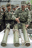 An Army officer displays rocket launchers, discovered during a search operation, in a camp in Ziran village in the area of Tangmarg, 39 km west of Srinagar, on Saturday. 