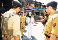 An unidentified Kashmiri is taken into custody by border guards during a search operation in Srinagar on Wednesday.