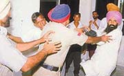A policeman tries to separate BJP municipal councillor.