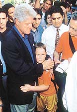 Former President Bill Clinton hugs an unidentified boy on University Place in New York on Thursday.