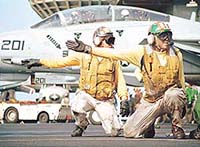 Flight deck shooters signal a plane clear to launch on catapult four of aircraft carrier USS Enterprise.
